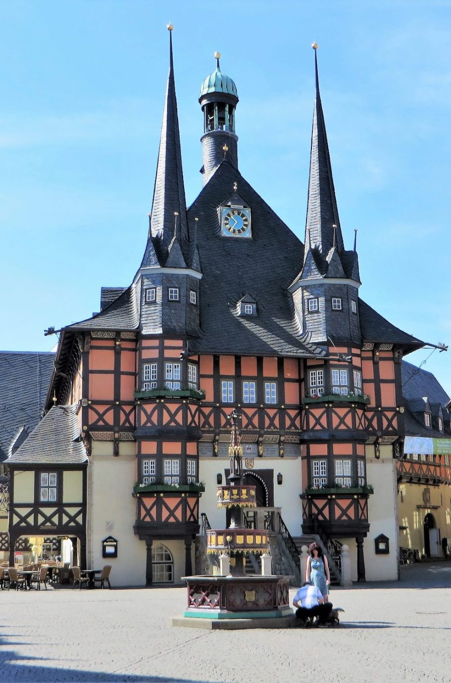 Wernigeröder Rathaus Historisches Rathaus mit spitzen Türmen und Brunnen im Vordergrund, blauer Himmel.