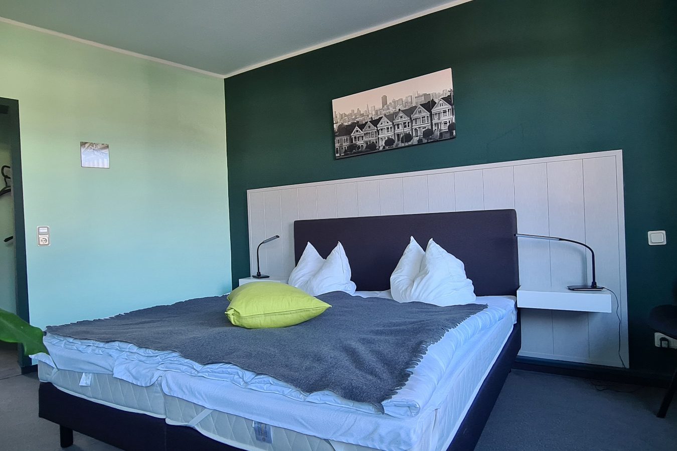 Doppelzimmer Doppelzimmer mit Doppelbett, grünen Wänden und moderne Einrichtung.